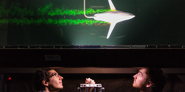 Graduate students visualize the aerodynamics of a model using vibrant GREEN dye in the water channel in the Experimental Fluid Dynamics research laboratory at UTIAS.