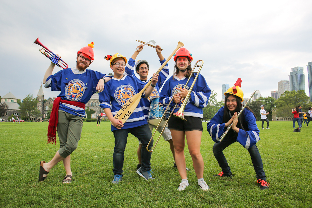 Five Lady Godiva Memorial Band members posing for a photo with their instruments