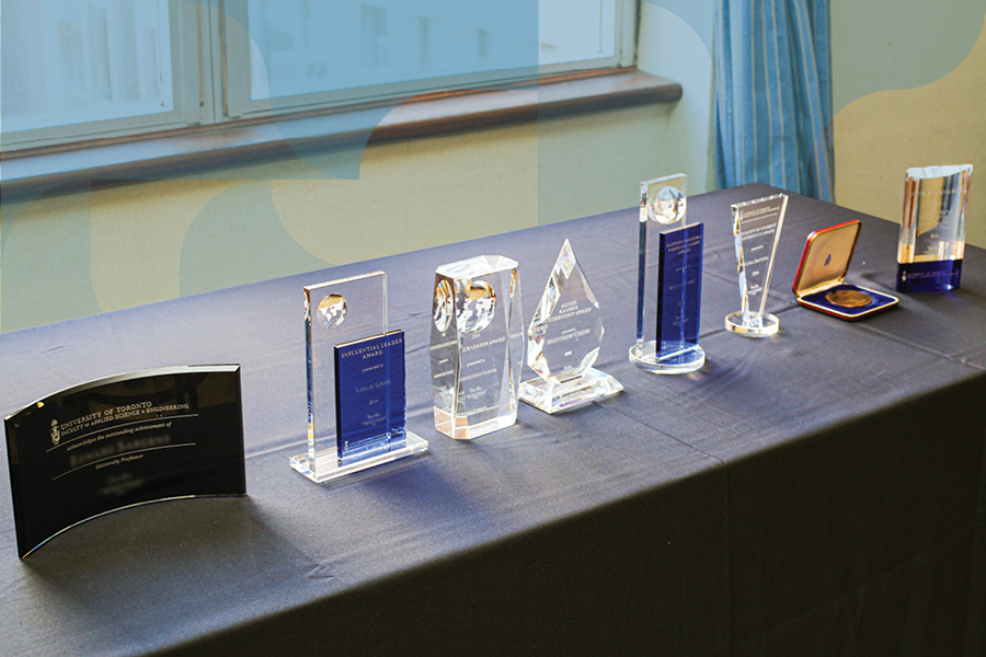 Eight awards for faculty and staff members sitting on a lined table.