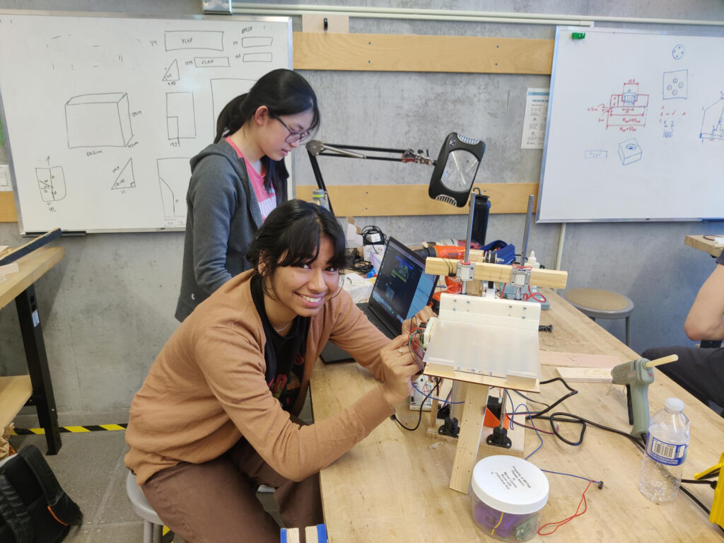 Two students sitting at a table working on a project