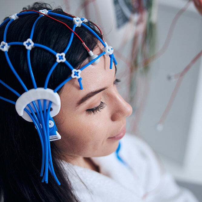 patient undergoing eeg Woman with electroencephalography (EEG) gear on her head